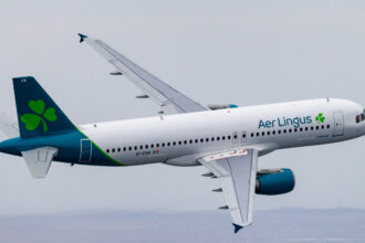 Emerald Airlines aircraft flying through the grey sky.
