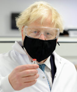 UK prime minister, Boris Johnson holding a vial of a COVID vaccine