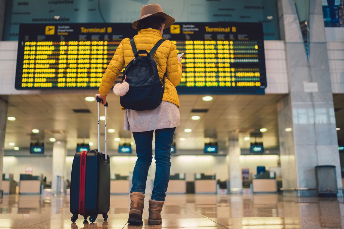 Women looking at departures board in an airport