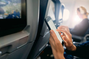 Close Up Of A Woman Using Her Phone On An Airplane Trip