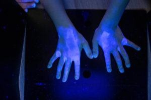 UV light revealing the germs on hands and surfaces