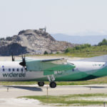 Widerøe aircraft on runway with mountains in the background