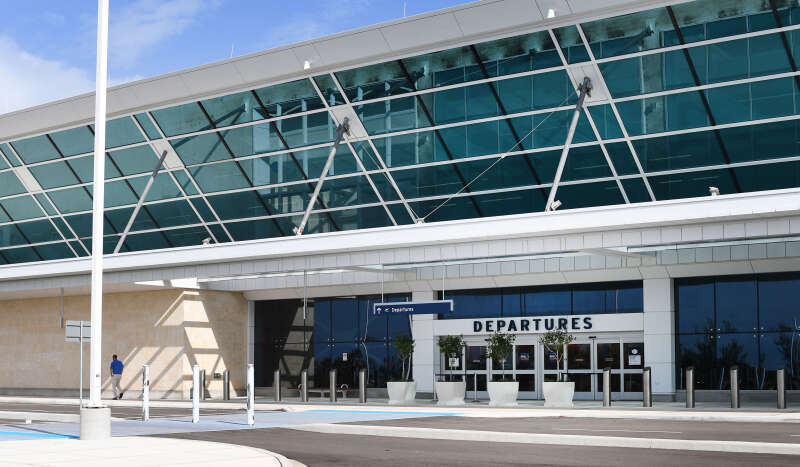 The entrance to L. F. Wade International Airport in Bermuda. The "Departures" sign is clearly displayed above the door and the building has a large glass roof. 