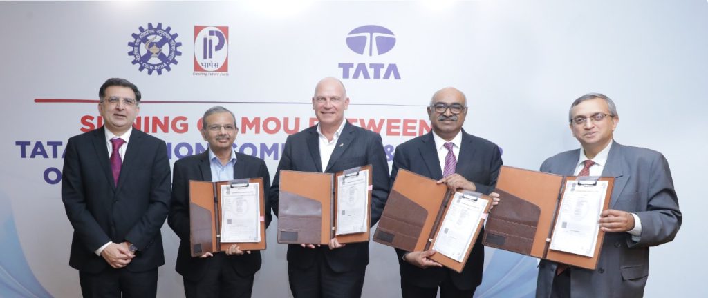 Representatives from three Indian airlines sign MoU. Five men in suits stand in a row, four of which are holding up documents.