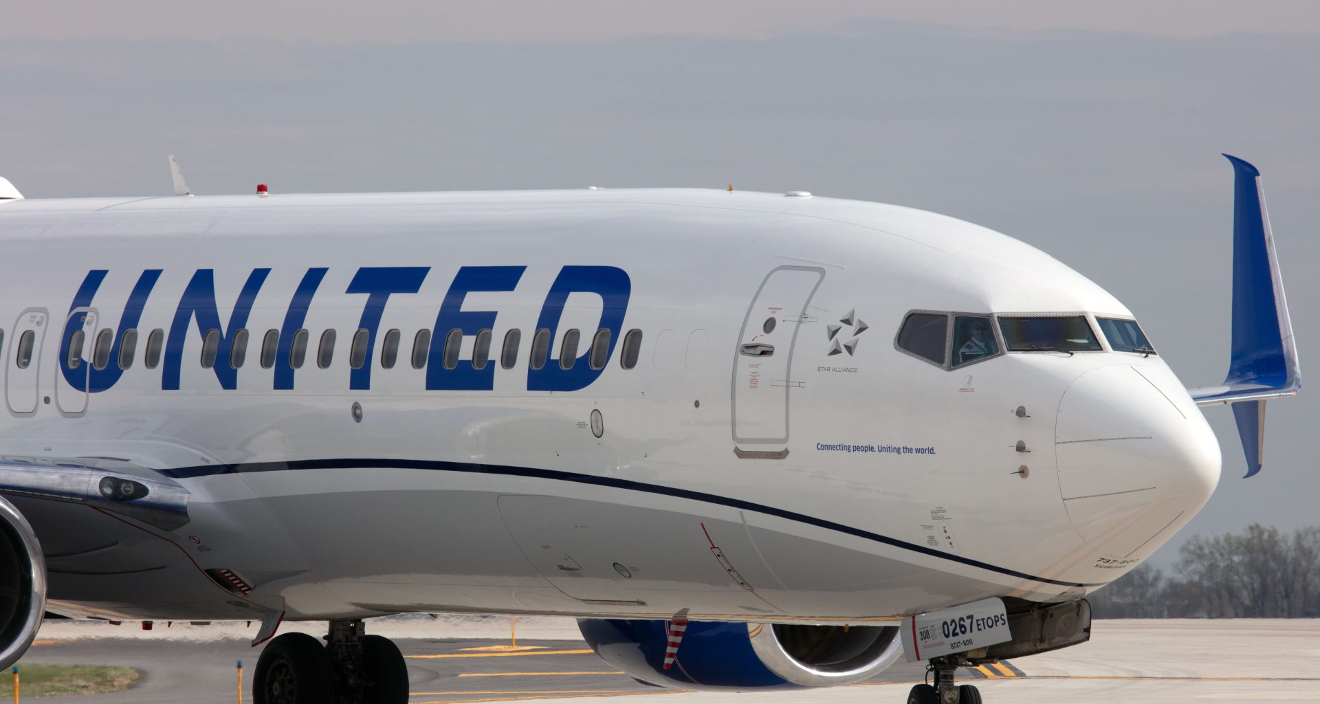 The front section of a United Airlines aircraft exterior as it sits on a runway.