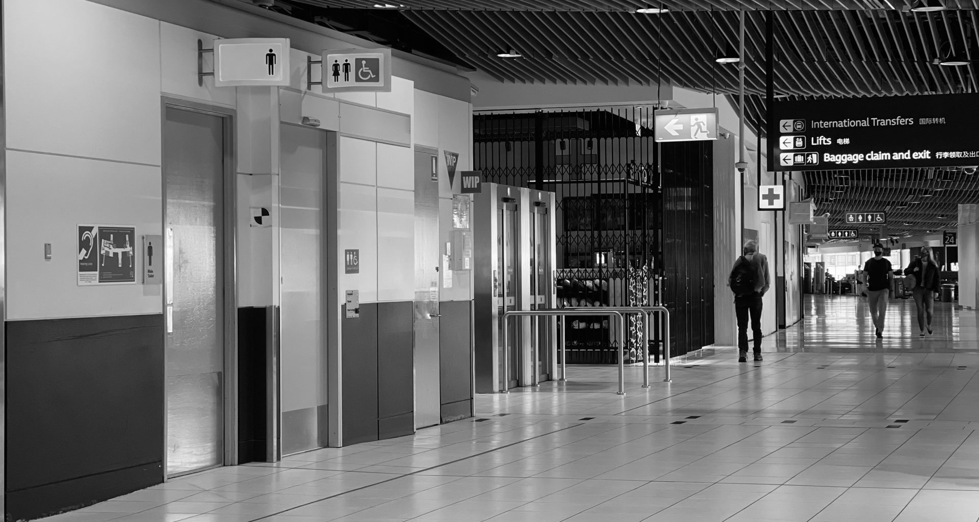Black and white image of inside an almost deserted airport