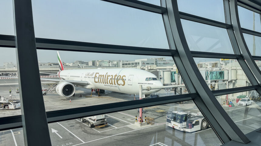 DUBAI, UAE. 16 SEPTEMBER 2023. In departure, view through glass: Boeing 777, passengers boarding, a prelude to the imminent journey