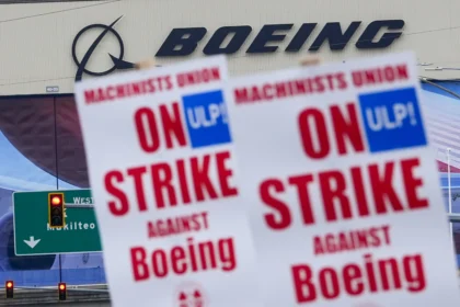 Strikers hold picket signs in front of Boeing's factory in Everett