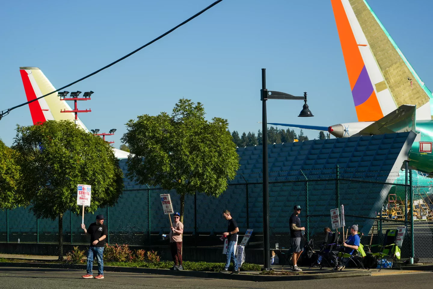 Workers with picket signs in front of Boeing 737 MAX aircraft in Renton