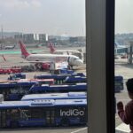 A boy looks at aircraft in an airport