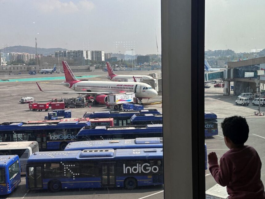 A boy looks at aircraft in an airport