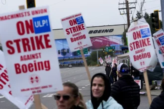Boeing workers wave picket signs as they strike on September 15, near the company's factory