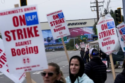 Boeing workers wave picket signs as they strike on September 15, near the company's factory