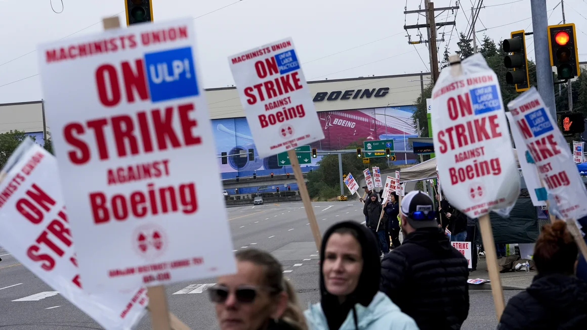 Boeing workers wave picket signs as they strike on September 15, near the company's factory