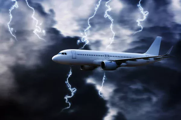 The image of a flying plane during thunderstorm.