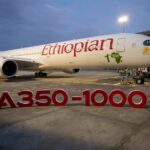 An Ethiopian Airlines Airbus plane behind an A350-1000 sign