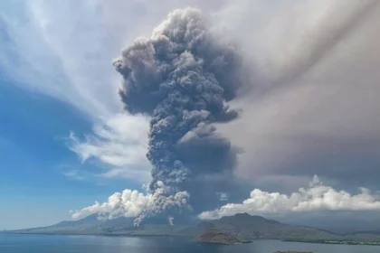 A big and tall grey mushroom of smoke fills the air of Flores