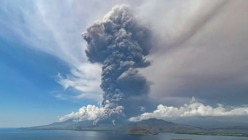 A big and tall grey mushroom of smoke fills the air of Flores