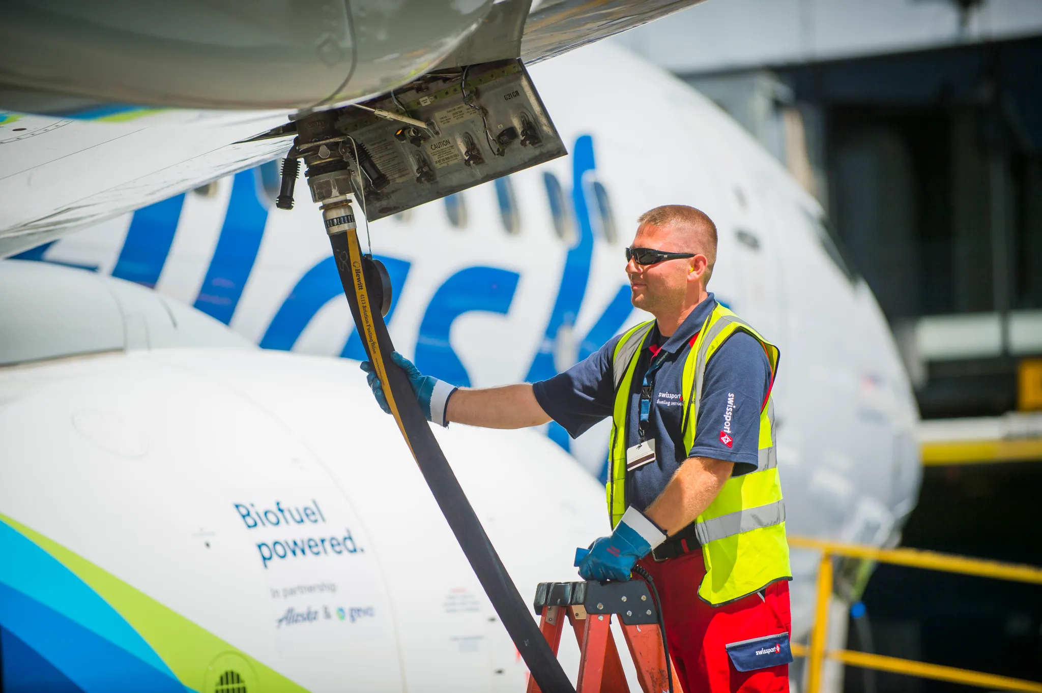 A man adds sustainable aviation fuel to a plane