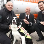 3 men and a SARDA IN search and rescue dog in front of an easyJet plane
