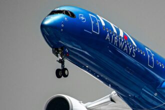 Blue ITA Airways flight with grey background