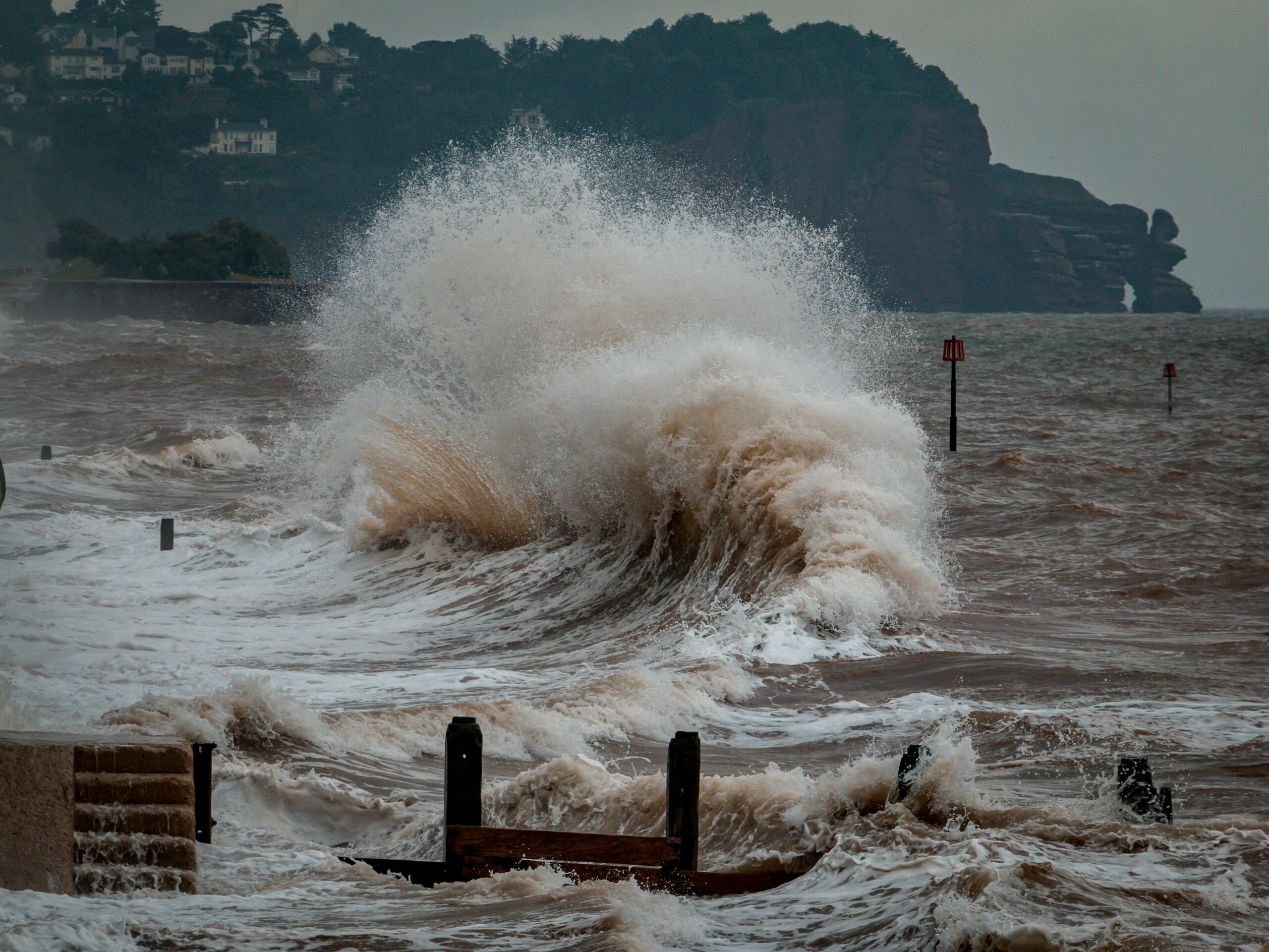 Powerful waves crash along a stormy coastline.