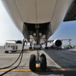 Ground crews prepare an aircraft, powering one of its engines with sustainable aviation fuel.