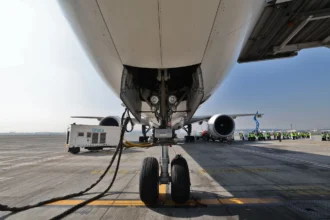 Ground crews prepare an aircraft, powering one of its engines with sustainable aviation fuel.