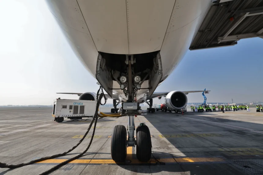 Ground crews prepare an aircraft, powering one of its engines with sustainable aviation fuel.