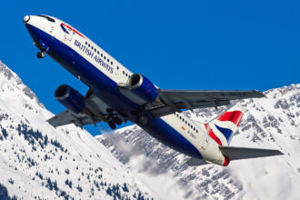 A British Airways 737 plane flying over snowy terrain. Direct flights from London Heathrow to Tromsø are now available.