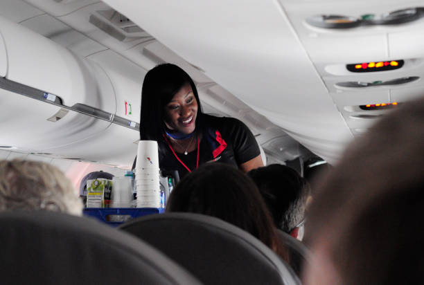 An American Airlines flight attendant conducts drink service on a flight