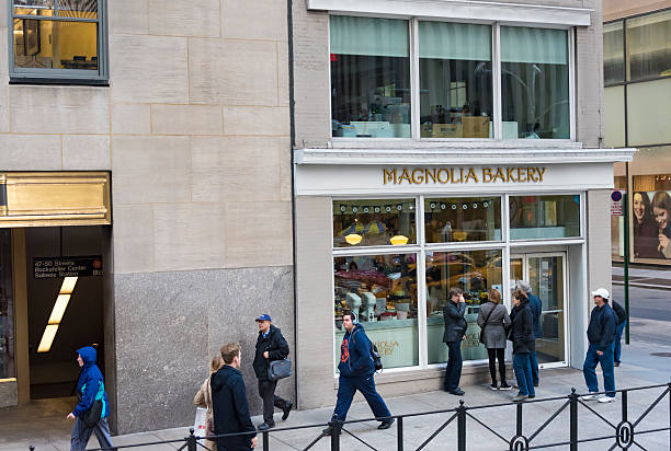 the outside of Magnolia Bakery located at Rockefeller Centre with people walking outside in on the street.