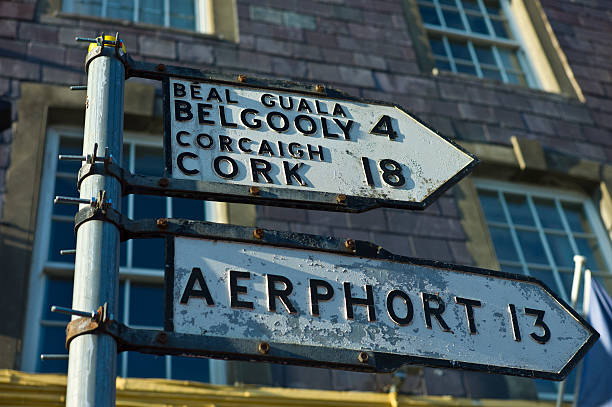 Street signs in Gaelic and English point the direction to Cork, the Airport and Gelgooly in County Cork, Ireland