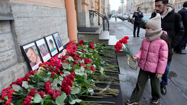 People laying flowers to honour the victims of the Azerbaijan Airlines crash.