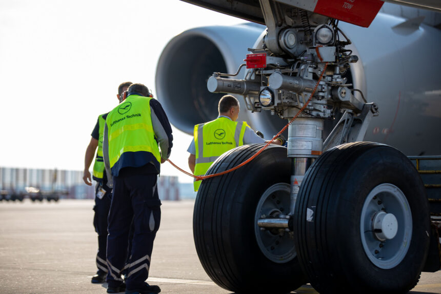 Image of ground staff next to plane wheels wearing hi-vis jackets with Lufthansa logo.