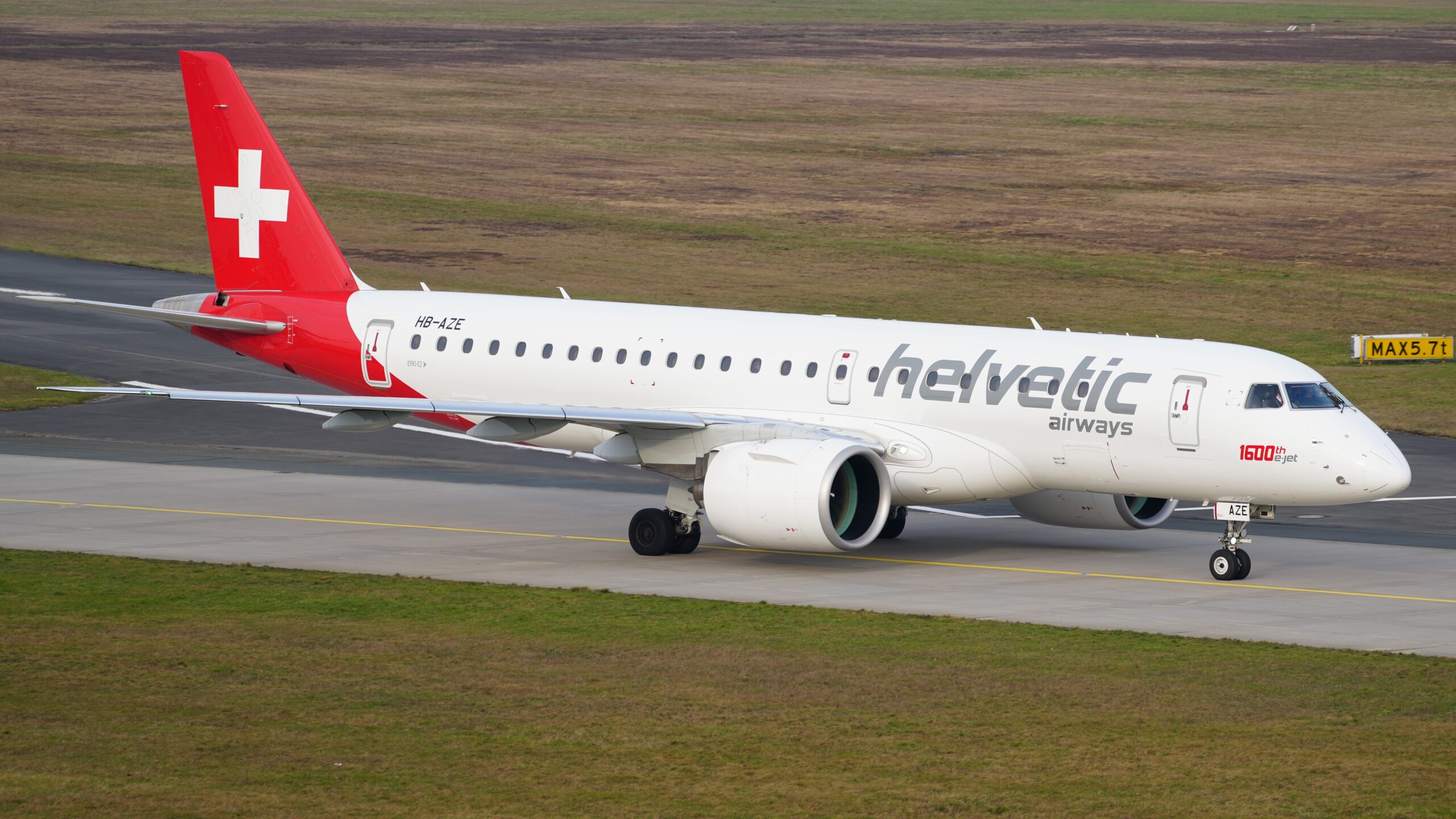 Helvetic Airways Embraer E190-E2 jet on runway.