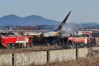 Wreckage of the Jeju Air flight crash at Muan International Airport with emergency responders on site.