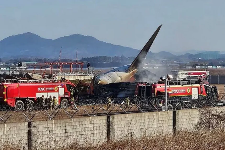Wreckage of the Jeju Air flight crash at Muan International Airport with emergency responders on site.