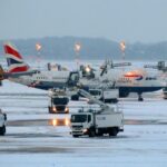 Staff at Manchester airport applying de-icer to aircrafts