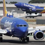 A Southwest Airlines plane takes off as another Southwest jet taxis