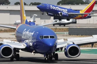 A Southwest Airlines plane takes off as another Southwest jet taxis