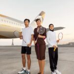 Image of Etihad staff with badminton players in front of etihad aircraft