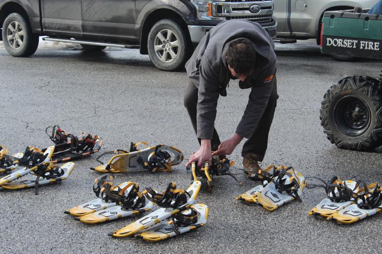Emergency responder preparing snowshoes for rescue efforts after Mount Equinox plane crash.