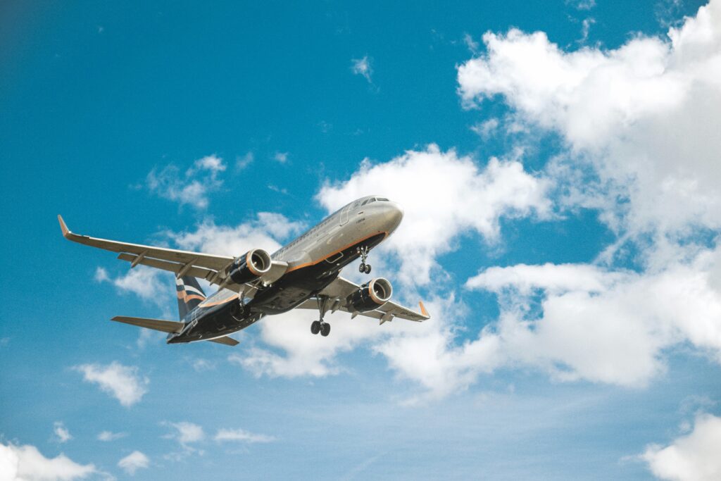 Airplane with stripes flying in a cloudy sky