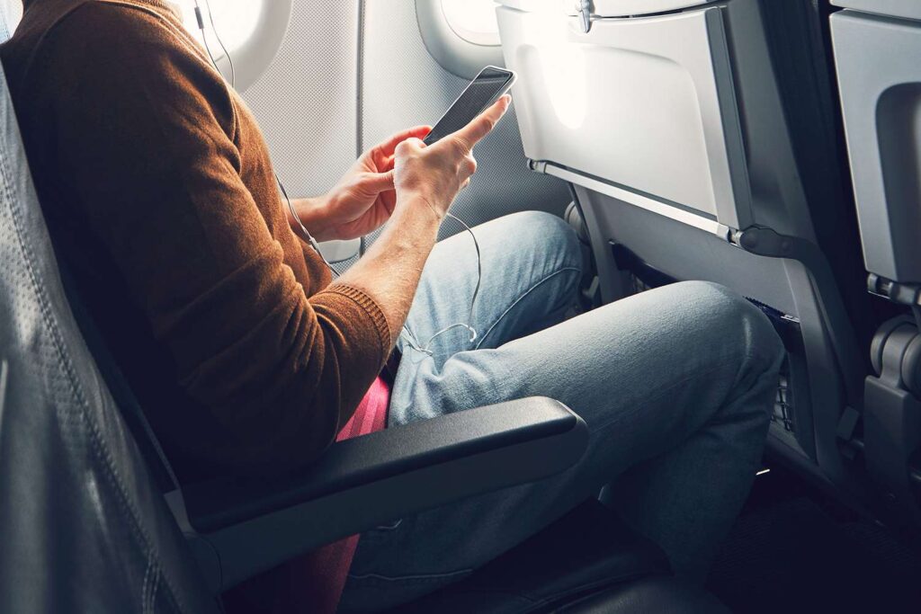 Passenger using smartphone onboard plane