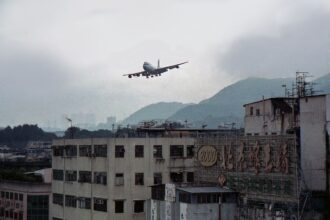 A plane flying very close to residential areas in Kowloon as it is approaching Kai Tak Airport.