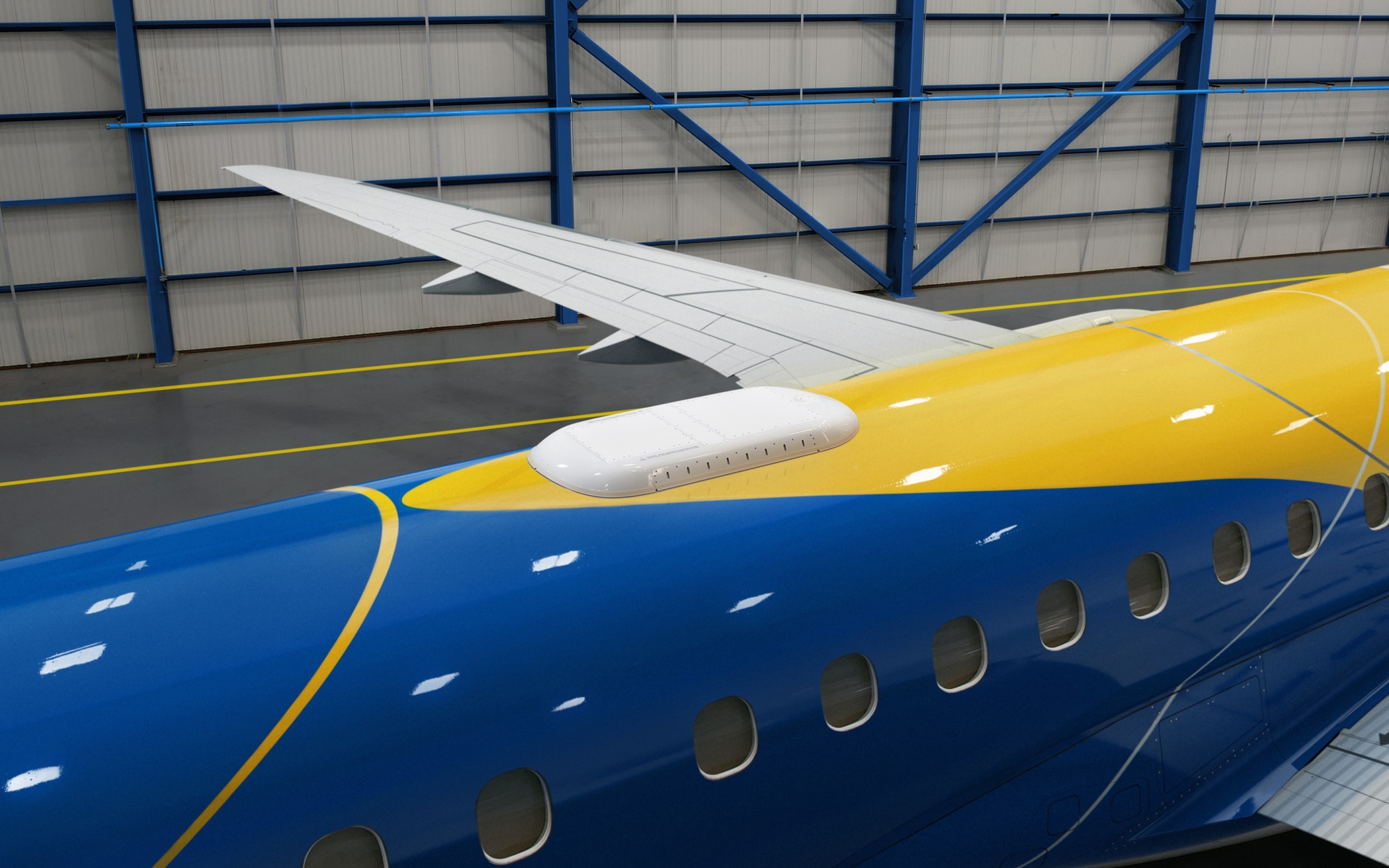 Aircraft fuselage showing a white Wi-Fi antenna near the wing, painted in bright blue and yellow, with hangar interior in background.