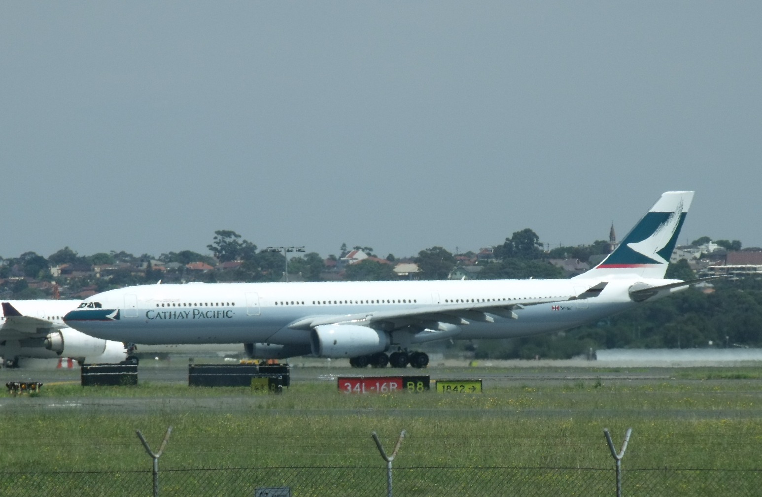 Cathay Pacific A330 taxiing past the parked aircraft in Sydney