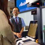 An Alaska Airlines staff member assisting a passenger