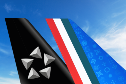 Image shows the tail designs of two aircraft; one black with a silver star pattern and the other blue with colorful symbols, against a blue sky.